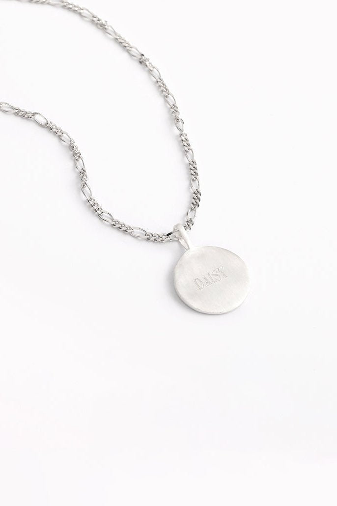 Engraved silver round pendant necklace with figaro-style chain.