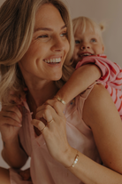 Mum and daughter wearing matching 9ct solid gold Pink Darling Bracelets with pink heart detail