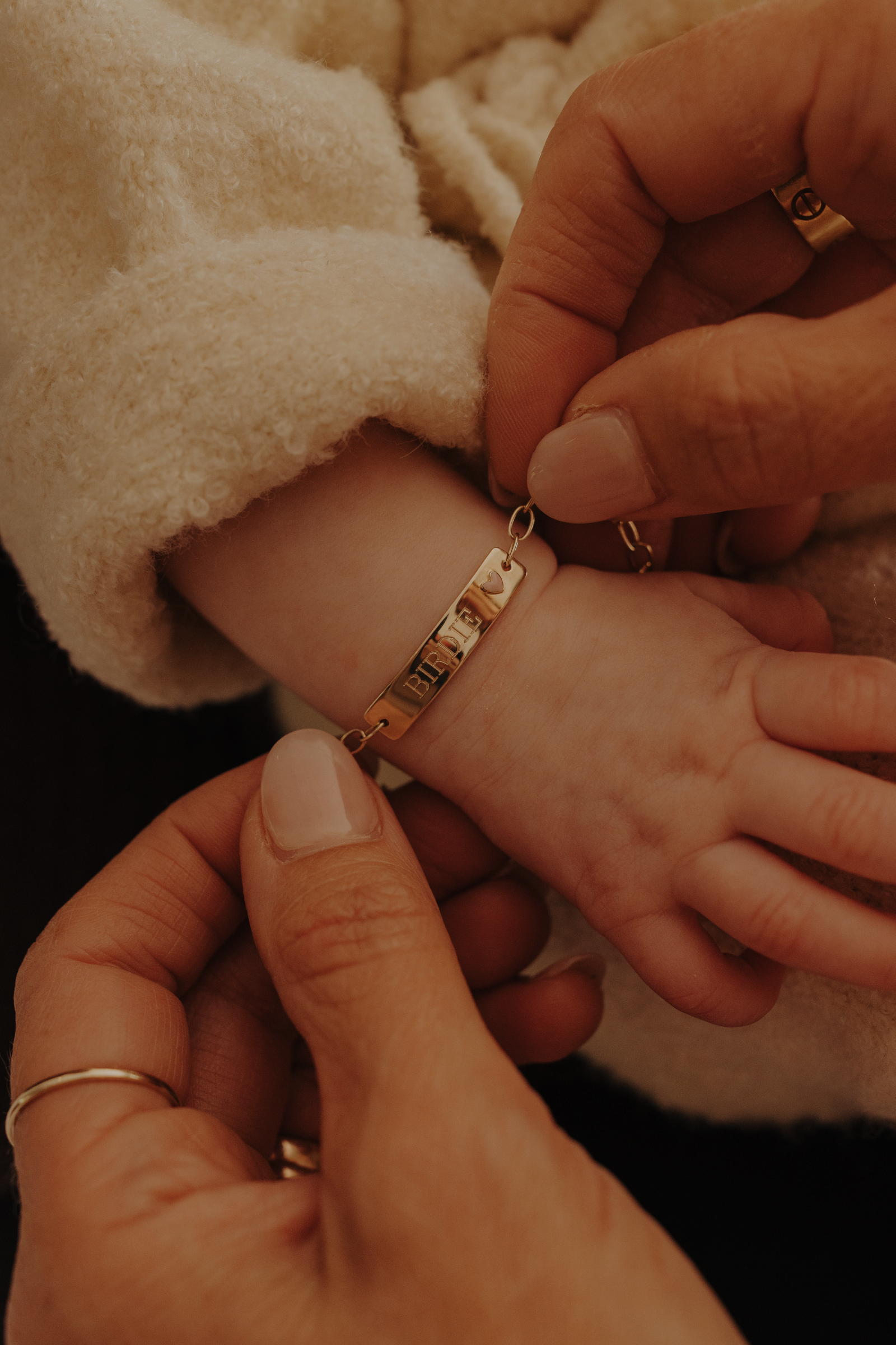 Close-up of baby hand wearing engraved 9ct solid gold Pink Darling Bracelet, a forever keepsake