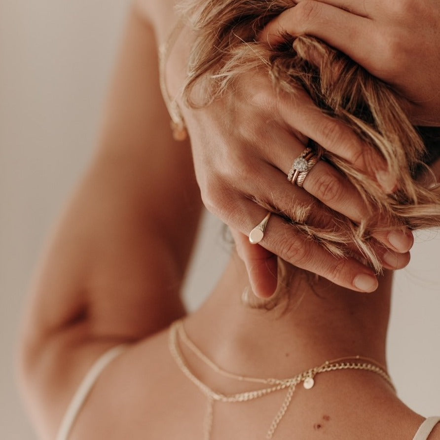 A solid 9ct gold signet ring looking elegant on a woman's finger.  It pairs beautifully with her vintage style rings.