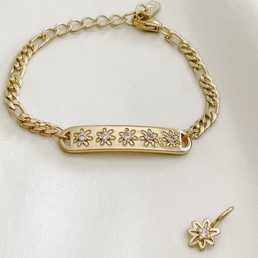 The Daisy Bracelet by Bluebird Jewellery, featuring five hand-drawn daisies with pink cubic zirconia centres, crafted as a feminine and floral fine jewellery piece.