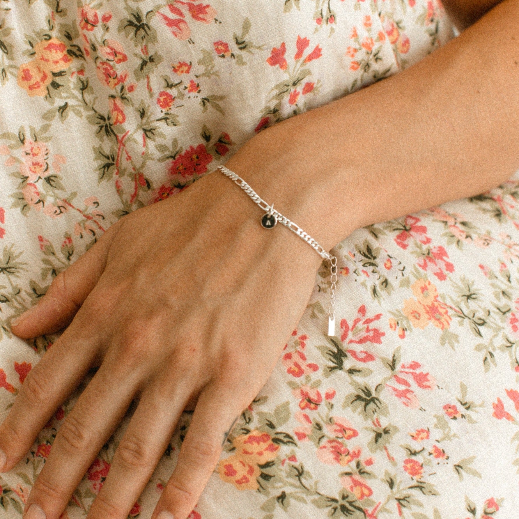 A Figaro Bracelet in adult length worn with one 6mm initial pendant by Bluebird Jewellery
