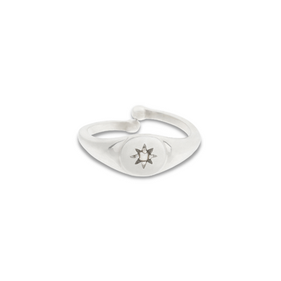 An adjustable child sized signet ring that features a beautiful seed pearl at its centre that is set within a vintage star design.
