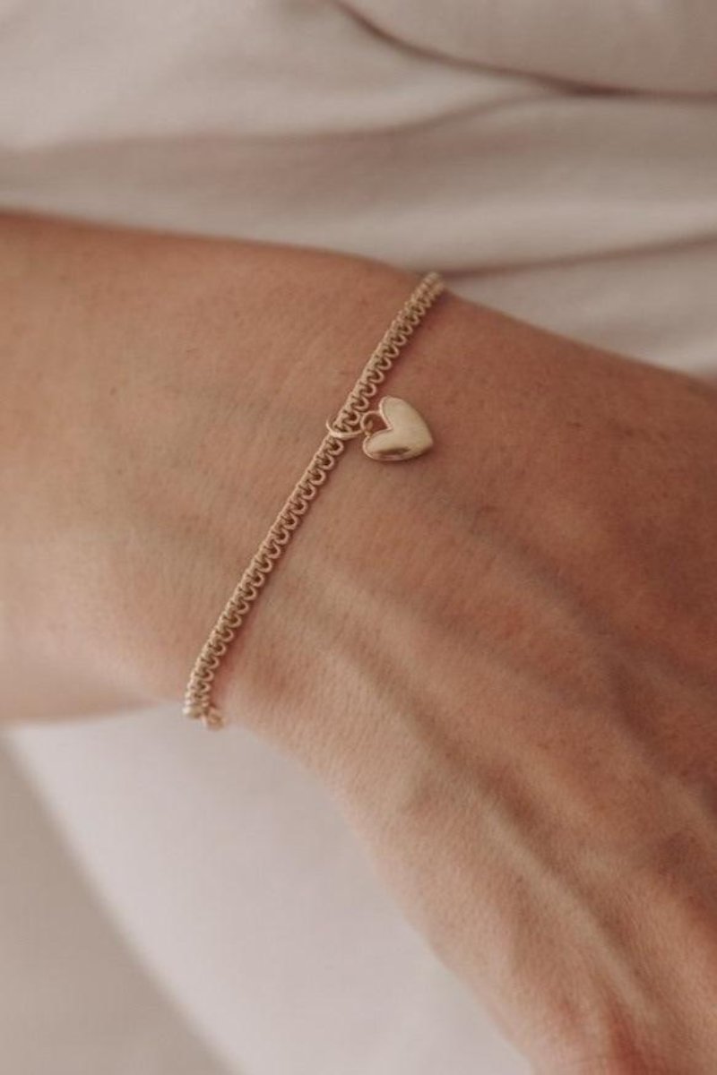 A woman wearing a Sweetheart Lace Chain Bracelet with a regular-sized Sweetheart pendant, crafted as an elegant everyday fine jewellery piece by Bluebird Co
