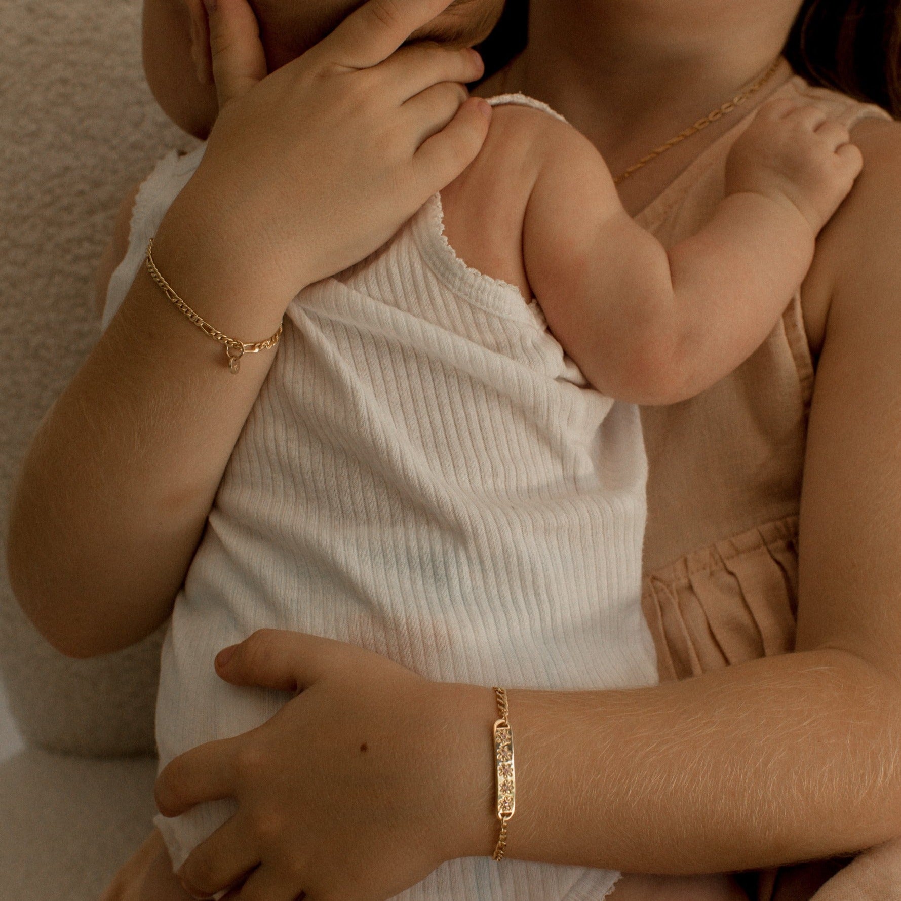 A girl is wearing the child length Daisy Bracelet in Gold Vermeil