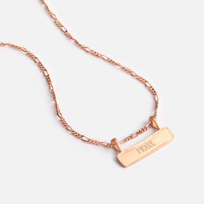 A close up look at the Signature Bar Necklace with the name Pearl engraved on it.